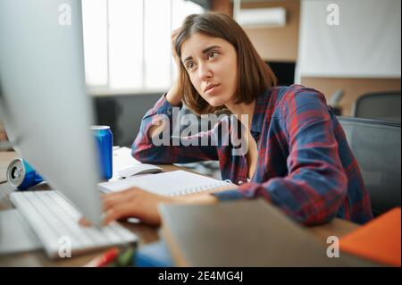 Müde IT-Spezialist arbeitet am Computer im Büro Stockfoto