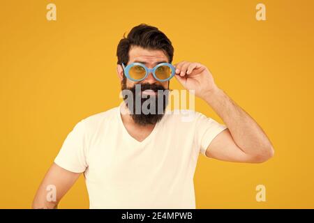 Halten Sie die Augen in der Sonnenbrille geschützt. Bärtiger Mann trägt eine Brille gelben Hintergrund. Modeparty Accessoire. Modischer Look mit modischem Flusspferd. Brillentrends. Mode und Stil. Stockfoto