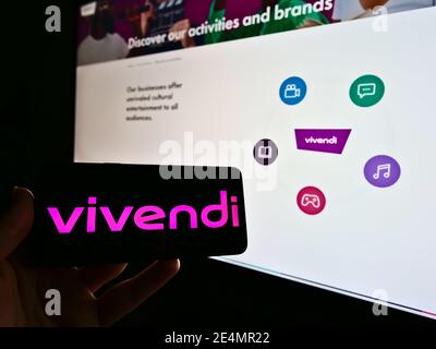 Person, die Mobiltelefon mit Logo des Franch-Medienkonzerns Vivendi SA auf dem Bildschirm vor der Website hält. Konzentrieren Sie sich auf das Smartphone-Display. Stockfoto