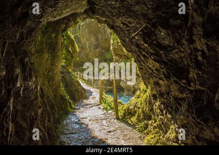 Der Wanderweg entlang des Flusses Tolminka, der durch die Tolminschlucht fließt, führt durch einen Felstunnel im Nationalpark Triglav im Nordwesten Sloweniens Stockfoto