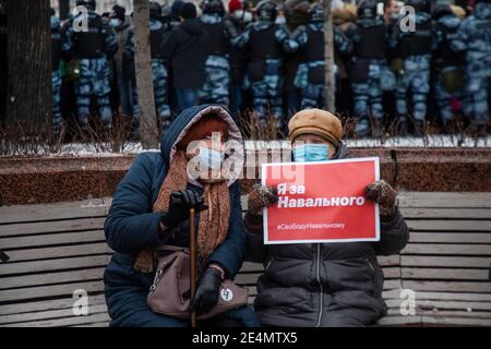 Moskau, Russland. 23. Januar 2021 Frauen sitzen auf einer Bank auf dem Puschkinskaja-Platz während einer unerlaubten politischen Kundgebung zur Unterstützung des Oppositionsführers Alexej Nawalny in Moskau, Russland. Auf dem Banner steht: 'Ich unterstütze Navalny' Stockfoto