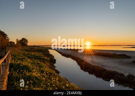 Schöner Sonnenuntergang über Feuchtgebieten und Sumpfgebieten mit einem bunten Himmel Und ein Sonnenstern am Horizont Stockfoto