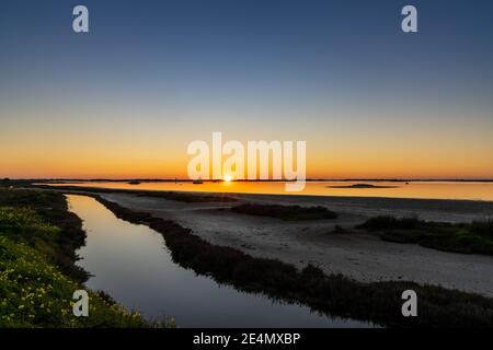 Schöner Sonnenuntergang über Feuchtgebieten und Sumpfgebieten mit einem bunten Himmel Und ein Sonnenstern am Horizont Stockfoto