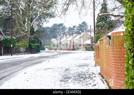 Eine Vorstadtstraße in rReading, Großbritannien ist mit Schnee bedeckt, eine Decke aus Weiß, aber Auto und Fuß Spuren eine slushy in der weißen. Stockfoto