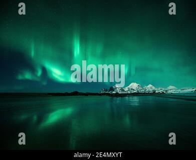 Nordlichter / Aurora Borealis bei Storsandnessanden, Lofoten, Norwegen, nachts im Winter, im Wasser reflektiert. Stockfoto