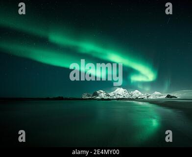 Nordlichter / Aurora Borealis bei Storsandnessanden, Lofoten, Norwegen, nachts im Winter, im Wasser reflektiert. Stockfoto