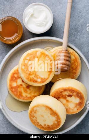 Quark fritters Syrniki mit Honig. Draufsicht. Ricotta Fritten oder Pfannkuchen Stockfoto