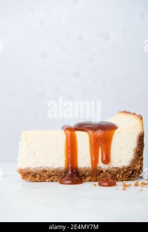 Käsekuchen mit gesalzener Karamellsauce isoliert auf Beton Hintergrund, kopieren Platz für Grafiken, Design oder Text Stockfoto