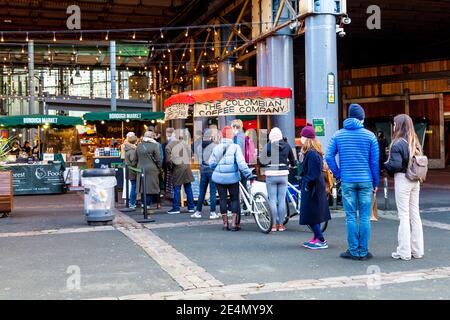 23. Januar 2021 - London, Großbritannien, geschäftiges Borough Market während der 3. Coronavirus-Sperre warten die Leute in einer Schlange an einem Kaffeestände Stockfoto