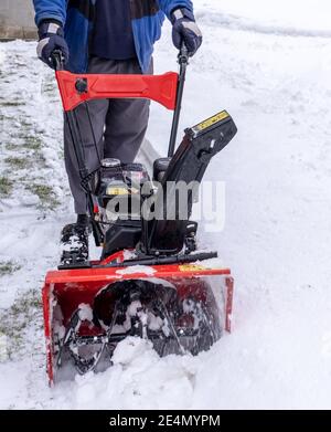 Arbeiter leicht räumt Straße oder Hof von Schnee durch Schneefräse Im Winter Stockfoto