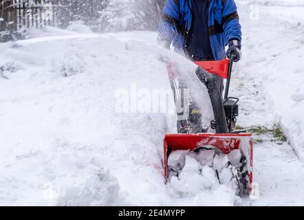 Arbeiter leicht räumt Straße oder Hof von Schnee durch Schneefräse Im Winter Stockfoto