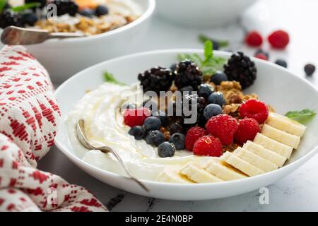 Joghurtschale mit Beeren, Obst und Müsli Stockfoto