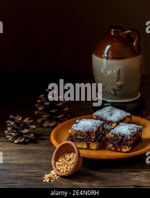 Hausgemachte Desserts mit Biskuitkuchen, Schokolade, Kokosflocken, Kakao und gehackten Haselnüssen, auf dunklem Hintergrund Stockfoto