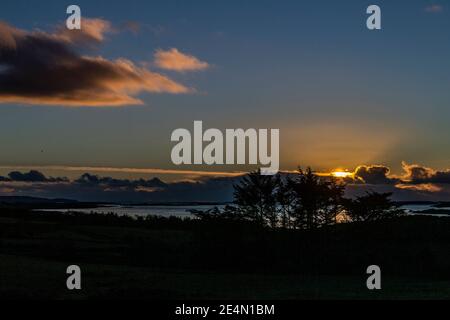 Roaring Water Bay, West Cork, Irland. Januar 2021. Die Sonne geht über den Muschelfarmen in der Roaring Water Bay nach einem Tag voller Schnee, Sonne und Temperaturen unter dem Gefrierpunkt unter. Quelle: AG News/Alamy Live News Stockfoto