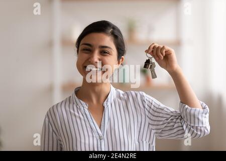 Junge gemischte Rasse Frau stolz Hausbesitzer zeigt Schlüssel der Wohnung Stockfoto