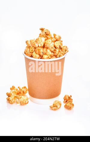 Köstliches süßes Popcorn mit Karamell in einfacher Papiertasse, isoliert auf weißem Hintergrund Stockfoto