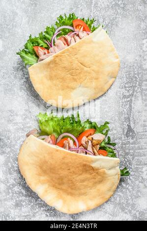 Döner Kebab mit gegrilltem Hähnchenfleisch und Gemüse in Pita-Brot. Grauer Hintergrund. Draufsicht Stockfoto