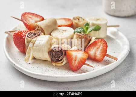 Spieße von Pfannkuchen Crepes mit Nussbutter und Obst Stockfoto