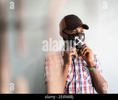 Junger schwarzer Mann mit Maske im Gesicht Stockfoto