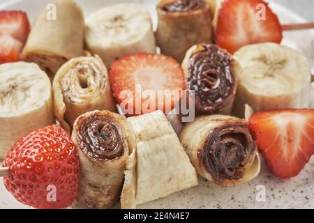 Spieße von Pfannkuchen Crepes mit Nussbutter und Obst Stockfoto