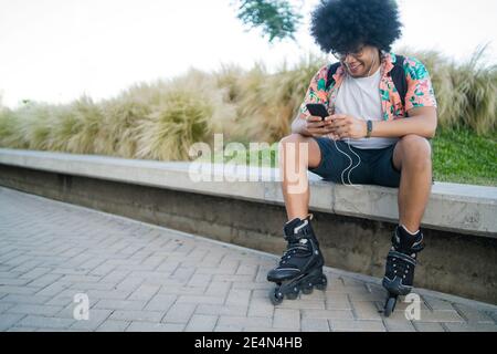 Junger Mann, der sein Mobiltelefon im Freien benutzt. Stockfoto