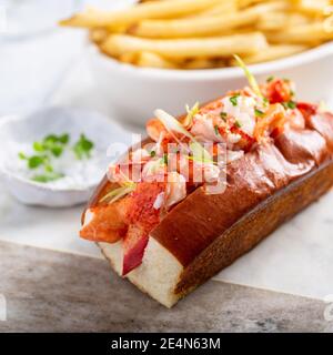 Hummerrolle mit Pommes auf einem Marmorbrett Stockfoto