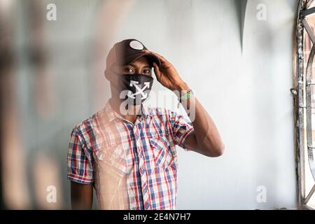 Junger schwarzer Mann mit Maske im Gesicht Stockfoto