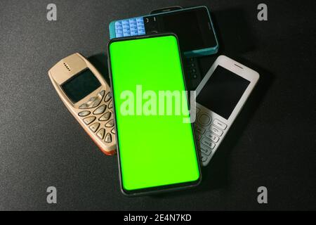 Neues Smartphone grünen Bildschirm auf alten Gen Handys, Technologie-Konzept Stockfoto