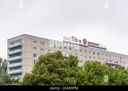 Berlin, Deutschland - 30. Juli 2019: Wohngebäude aus der sowjetzeit in Ost-Berlin ein wolkiger Sommertag. LKW Tatra Motokov Schild. Stockfoto