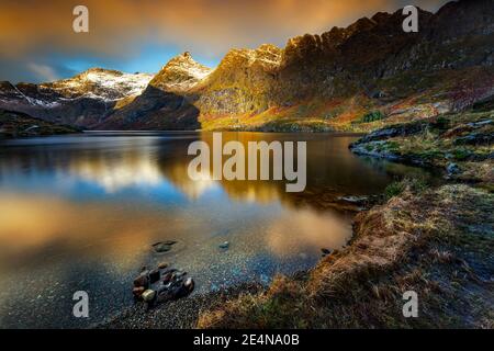 Malerische Landschaft der Lofoten Inseln in mildem Sonnenuntergang Licht. Wunderschöne Aussicht auf die majestätischen Berge rund um den See. Wunderschönes Norwegen Stockfoto