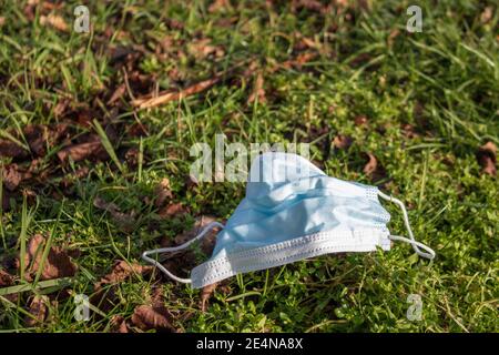 Einweg Ohrbügel Gesichtsmaske Müll in der Natur. Abfall während der COVID-19-Pandemie Stockfoto