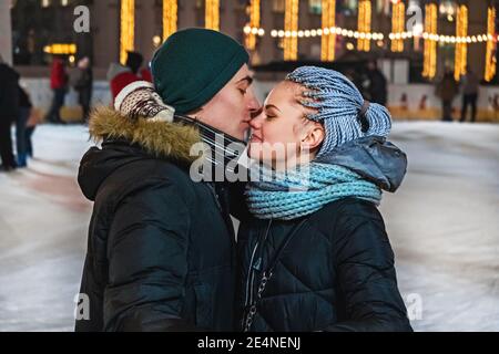 Ein paar Liebhaber umarmen und küssen auf der Eisbahn am valentinstag oder weihnachten. Freizeitaktivitäten, Erholung im Winter, aktiver Zeitvertreib Stockfoto