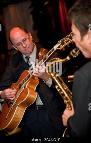 Duette mit Saxophon und Gitarre von zwei männlichen Musikern bei Eine Party Stockfoto