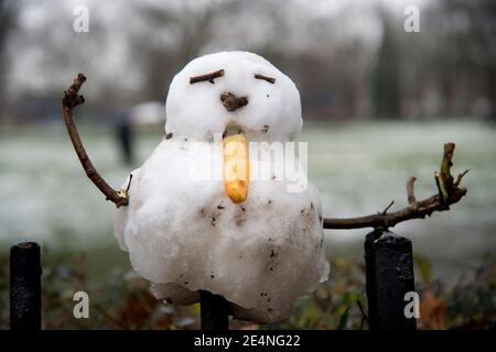 Hackney, London. VEREINIGTES KÖNIGREICH. London Fields. Kleiner Schneemann im Park auf einem Zaun. Stockfoto