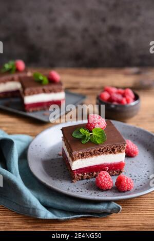 Süßes Dessert, leckere Schokolade Himbeer Käsekuchen, gekrönt mit Schokolade Zuckerguss Stockfoto