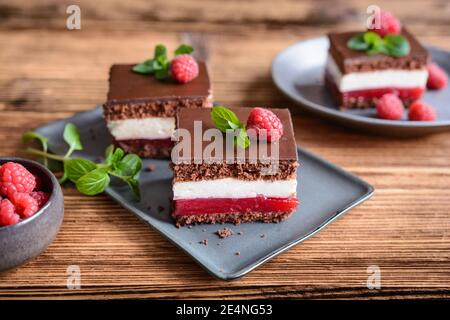 Süßes Dessert, leckere Schokolade Himbeer Käsekuchen, gekrönt mit Schokolade Zuckerguss Stockfoto