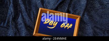 Beschriftung Tag frei. Text in einem Holzrahmen auf einem charmanten schimmernden Hintergrund in marineblauem Lurex-Stoff. Stockfoto