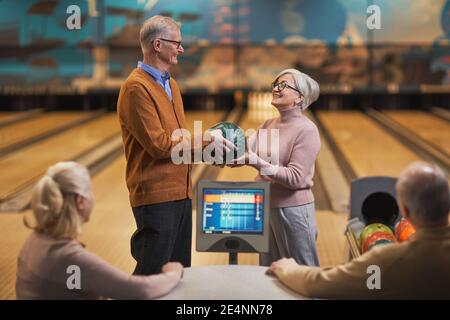 Portrait von glücklichen Senior-Paar Bowling zusammen mit Gruppe von Freunden im Entertainment-Center, kopieren Raum Stockfoto