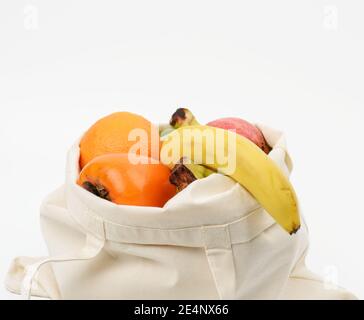 Beigefarbene Stofftasche mit frischen Früchten auf weißem Hintergrund, Null wast Stockfoto
