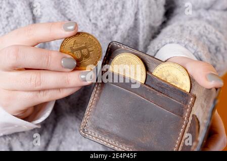 Nahaufnahme Foto von Frau Hand setzen Bitcoin in Brieftasche. Stockfoto