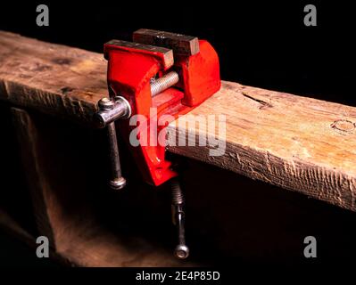 Schlosser Werkzeug Metall-Schraubstock auf einem Holztisch befestigt. Stockfoto