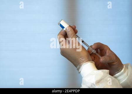 Nahaufnahme der Hände eines Arztes, der eine injizierbare Dosis eines Impfstoffs vorbereitet. COVID-19 Konzept Stockfoto