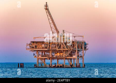 Am 4. März 2016 geht die Sonne auf einer ExxonMobil Erdgasanlage im Golf von Mexiko in Dauphin Island, Alabama, unter. Stockfoto