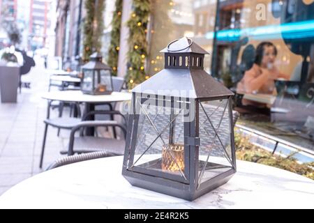 Helsinki. Finnland. 19. Januar 2021 Laterne im Schnee auf dem Tisch. Straßencafé innen. Hochwertige Fotos Stockfoto