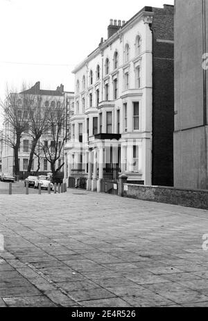 Großbritannien, West London, Notting Hill, 1973. Heruntergekommene und heruntergekommene, große, vierstöckige Häuser werden langsam restauriert und neu dekoriert. Powis Square (links unten) & direkt rechts (aus dem Bild) ist Colville Gardens. Schild an der Wand zur Talbot Road. Der gepflasterte Bereich ist außerhalb Allerheiligen Kirche. Die Terrasse am Powis-Platz, hinter dem Spielbereich, scheint abgerissen und neue Reihenhäuser errichtet worden zu sein. (Mitte links im Bild).* Dies muss überprüft werden*. Stockfoto