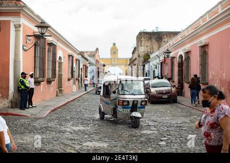 Tuk-Tuk öffentlichen Verkehrsmitteln Fahrzeug durch die Santa Catalina Arch in Antigua, Guatemala, Mittelamerika Stockfoto