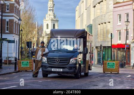 UPS Lieferung Fahrer Pose für Foto von UPS LKW fahren Durch Straßenpflanzer reserviert für Rettungswagen in London Stockfoto