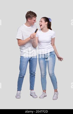 Paar singen zu Haarbürste isoliert. Pärchen, Die Spaß Haben Stockfoto