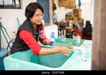 Eine Frau verwendet in ihrem Zuhause in Cantel, Guatemala, ein Wasserfiltersystem auf Leitungsbasis. Stockfoto