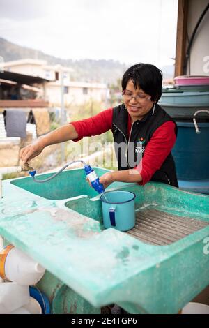 Eine Frau verwendet in ihrem Zuhause in Cantel, Guatemala, ein Wasserfiltersystem auf Leitungsbasis. Stockfoto